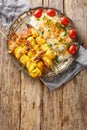 Grilled chicken kebab is known as jujeh kabab with rice closeup on the plate. Vertical top view Royalty Free Stock Photo