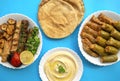 Grilled chicken, kofta kebab, mahshi, cabbage rolls, pita bread, tahini on white plate on a blue background, top view. Kafta kebab Royalty Free Stock Photo
