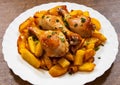 Grilled chicken leg and potatoes on the white plate on a wooden Royalty Free Stock Photo