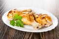 Grilled chicken legs, leaves of parsley in dish on wooden table