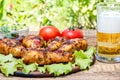 Grilled chicken legs and lettuce leaves on wooden chopping board