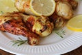 Grilled chicken legs with mustard on wooden table served on white plate with rosemary. BBQ dinner background Royalty Free Stock Photo