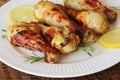 Grilled chicken legs with mustard on wooden table served on white plate with rosemary. BBQ dinner background Royalty Free Stock Photo