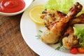 Grilled chicken legs with mustard on wooden table served on white plate with rosemary. BBQ dinner background Royalty Free Stock Photo