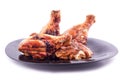 Grilled chicken legs to a crust in a black plate on a white background isolated Royalty Free Stock Photo