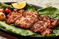 Grilled Chicken with lemon slice and tomato served in dish isolated on table top view of arabic food Royalty Free Stock Photo