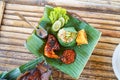 Grilled chicken with red barbecue sauce, vegetables and chili sauce served on banana leaves Royalty Free Stock Photo