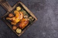 Grilled chicken and rosemary lemon and tomato are arranged in an appetizing black plate and served Placed on a black table With Royalty Free Stock Photo