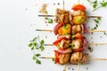 Grilled chicken skewers with bell peppers, onions, and a sprinkle of herbs on a white surface. Top view of barbecue Royalty Free Stock Photo