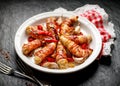 Grilled chicken tenderloin wrapped with bacon with addition chili peppers, garlic and herbs on white plate, black background Royalty Free Stock Photo
