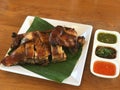 grilled chicken on white dish with spicy sauce on wood table. Royalty Free Stock Photo
