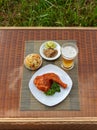 Grilled chicken on white plate with parsley, salad and beer outdoors Royalty Free Stock Photo