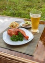 Grilled chicken on white plate with parsley, salad and beer outdoors Royalty Free Stock Photo