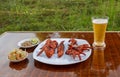 Grilled chicken on white plate with parsley, salad and beer outdoors Royalty Free Stock Photo