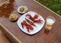 Grilled chicken on white plate with parsley, salad and beer outdoors Royalty Free Stock Photo