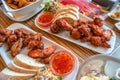 Grilled chicken wings, baked western potatoes, sweet Chinese souse and fresh salad in outdoor restaurant Royalty Free Stock Photo