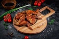 Grilled chicken wings on a dark stone table with vegetables, cream and tomato sauce. Served on a wooden board. Fast food restauran Royalty Free Stock Photo