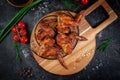 Grilled chicken wings on a dark stone table with vegetables, cream and tomato sauce. Served on a wooden board. Fast food restauran Royalty Free Stock Photo