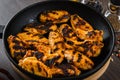 Grilled chicken wings in grill panwith spices, wooden background