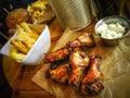 Grilled chicken wings and legs, garlic sauce, hamburger and potato chips Royalty Free Stock Photo