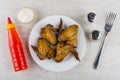 Grilled chicken wings in plate, ketchup, mayonnaise, salt, pepper