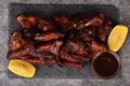 Grilled chicken wings on a plate with lemon and sauce Royalty Free Stock Photo