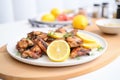 grilled chicken wings on a white plate, with lemon slices Royalty Free Stock Photo