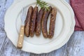 Grilled chipolata sausages on a plate Royalty Free Stock Photo