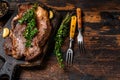 Grilled Chuck eye roll beef meat steak on a cutting board. Dark wooden background. Top view. Copy space Royalty Free Stock Photo