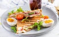 Grilled club sandwich panini with ham, tomato, cheese, avocado and cup of coffee. Royalty Free Stock Photo