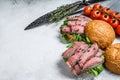 Grilled cold cuts roast beef burger sandwich with arugula and spinach. White background. Top view. Copy space Royalty Free Stock Photo