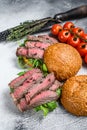 Grilled cold cuts roast beef burger sandwich with arugula and spinach. White background. Top view Royalty Free Stock Photo