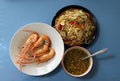 Grilled cooked shrimp in the white dish with the sauce in the bowl and papaya salad in the black dish. Royalty Free Stock Photo