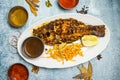 Grilled Coral Fish with salad, lemon and chili sauce served in a dish isolated on grey background top view of bangladesh food