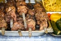 Grilled corn with assorted meat skewers or kebabs fresh from cooking over a barbecue fire on display at a market, buffet or