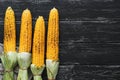 Grilled corn on the cob on a black wooden rustic background. Copy space, flat lay