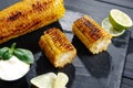 Grilled corn on the cob with butter and salt on the grill plate, close-up, top view. Royalty Free Stock Photo