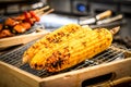 Grilled corn on the grill with blur BBQ beside. Royalty Free Stock Photo