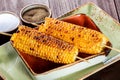 Grilled Corn with salt and butter on plate on dark wooden background, Closeup. Royalty Free Stock Photo