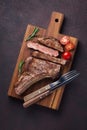 Grilled cowboy beef steak, herbs and spices on a dark stone background. Top view Royalty Free Stock Photo