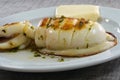 Grilled cuttlefish with sauce on a white plate. Delicious wholesome dinner at a Spanish fish restaurant. Royalty Free Stock Photo