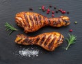 Grilled delicious chicken legs or chicken drumsticks on black slate serving plate. Flat lay Royalty Free Stock Photo