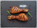 Grilled delicious chicken legs or chicken drumsticks on black slate serving plate. Flat lay Royalty Free Stock Photo