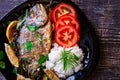 Grilled dorada fish with lemon, parsley, rosemary and tomatoes Royalty Free Stock Photo