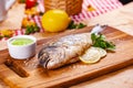 Grilled dorado fish with lemon and sauce on wooden board Royalty Free Stock Photo