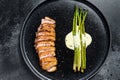 Grilled duck breast steak with baked asparagus. Black background. Top view Royalty Free Stock Photo