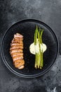 Grilled duck breast steak with baked asparagus. Black background. Top view