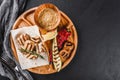 Grilled fillet fish and vegetables with spice sauce on cutting board over black stone background. Hot fish Dishes. Top view, flat