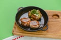 Grilled fillet mignon at the restaurant. Medallion steak dish with baked stuffed potato served in a frying pan Royalty Free Stock Photo