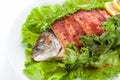 Grilled fish and bacon with lettuce and lemon. on